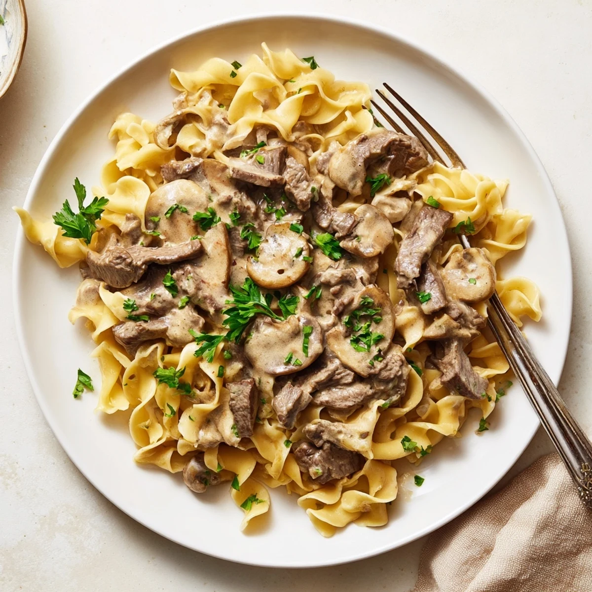 Creamy beef and mushroom stroganoff served over egg noodles with fresh parsley garnish