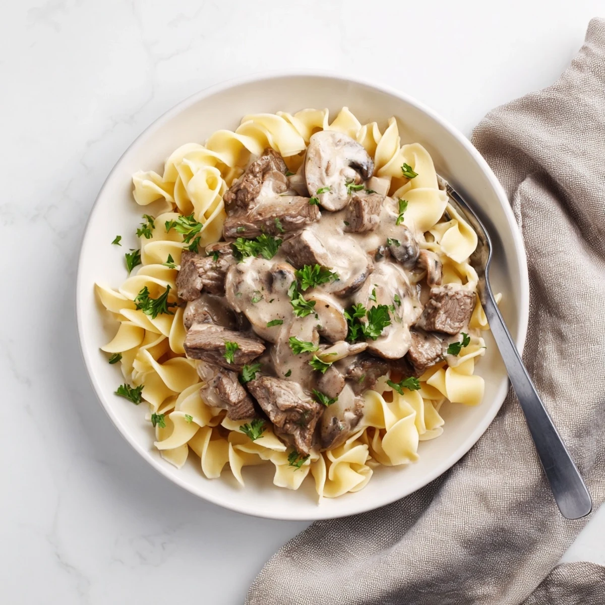 Tender beef strips in rich sour cream sauce with earthy sliced mushrooms over pasta