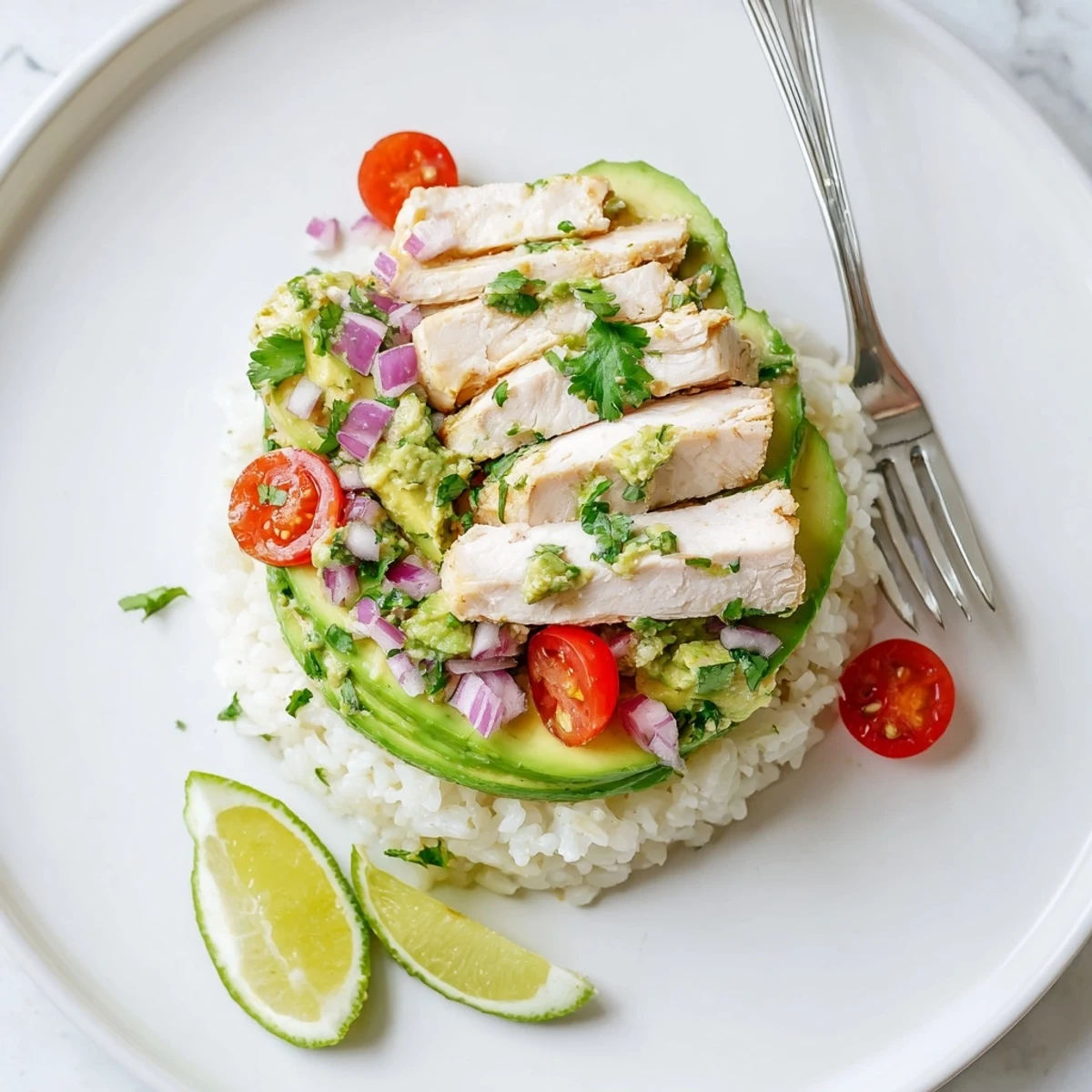 Close-up of Honey Lime Chicken Avocado Rice Stack with zesty lime-marinated chicken breast, buttery avocado cubes, and cherry tomato accents