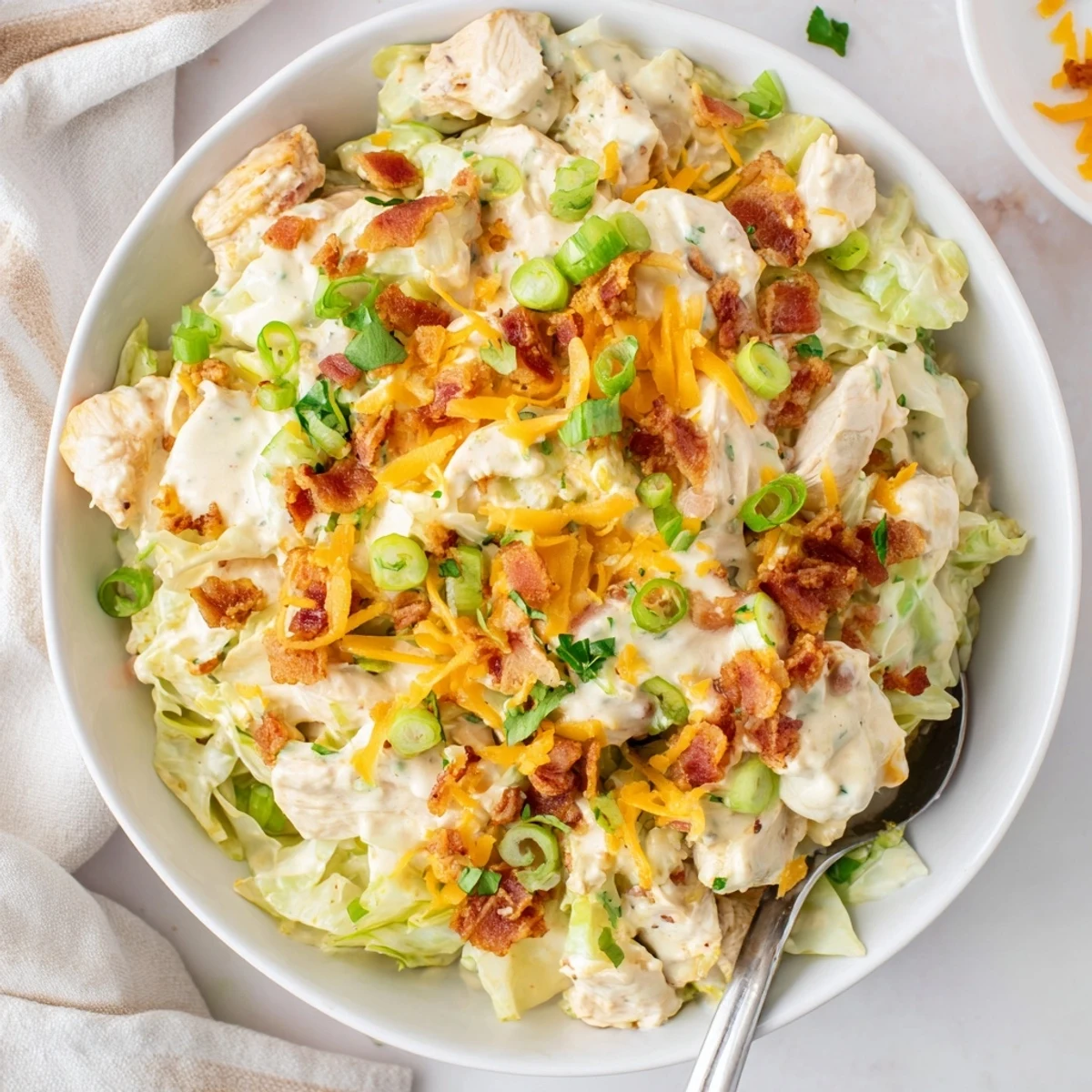 Creamy chicken bacon ranch cabbage bowls topped with melted cheddar and fresh green onions