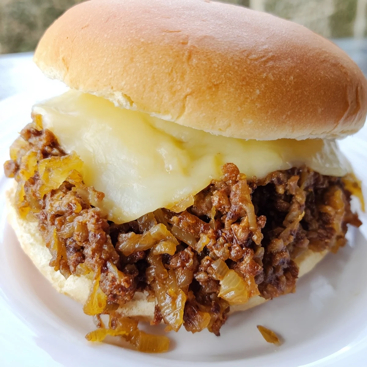 Golden brown caramelized onions and savory ground beef piled on a toasted bun topped with melted provolone cheese for French Onion Beef Sloppy Joes