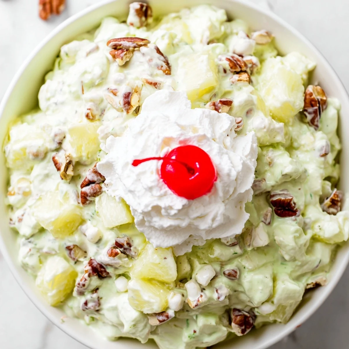 Nostalgic Watergate Salad recipe displaying fluffy pistachio pudding mixed with crushed pineapple and mini marshmallows for easy dessert