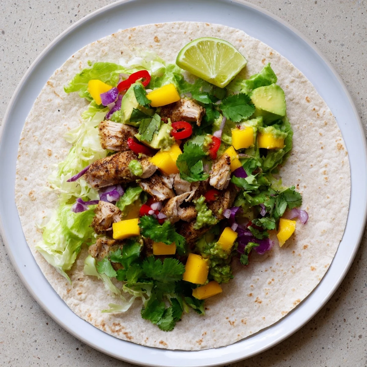 Fresh summer grilled chicken wraps featuring juicy spiced meat and colorful tropical fruit salsa