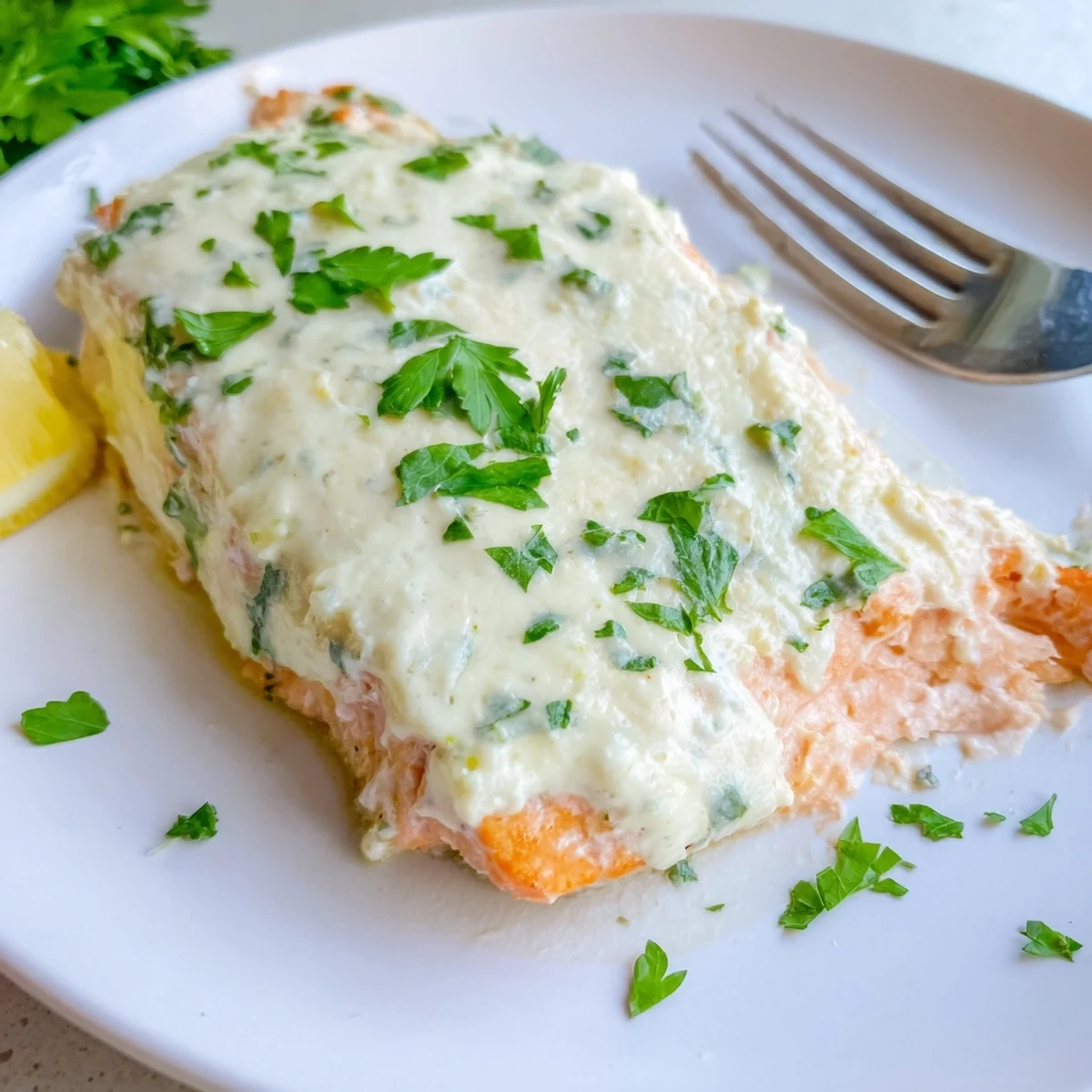 Creamy Boursin salmon fillets baked golden with herbs and fresh lemon wedges