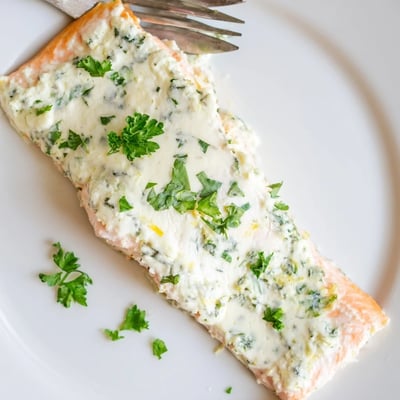 Tender baked salmon topped with melted Boursin cheese, parsley, and bright lemon zest