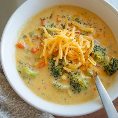 Thick slow cooker broccoli cheese soup topped with golden croutons in a cozy mug